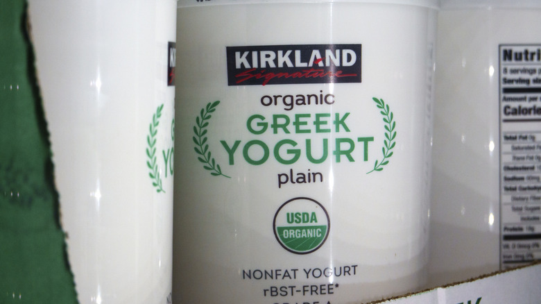 A container of Kirkland brand organic plain Greek yogurt on a shelf