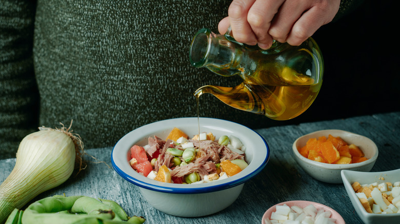 dressing a salad with oil
