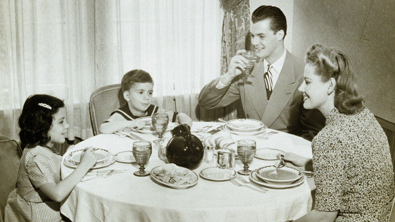 black and white photo of family sat at dinner table