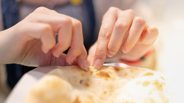 hand tearing of a piece of nan bread