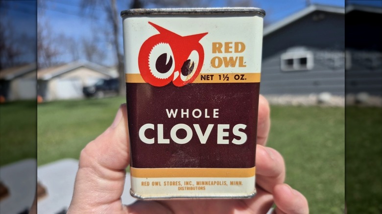 Hand holding vintage Red Owl grocery store branded whole cloves spice tin