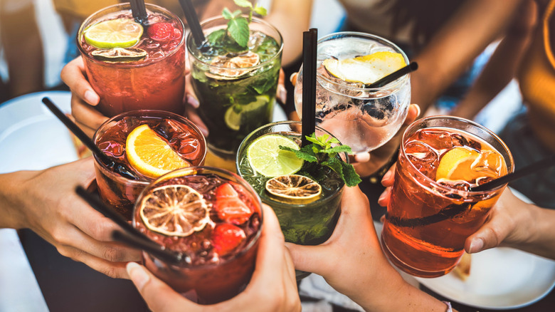People raising cocktails at a bar