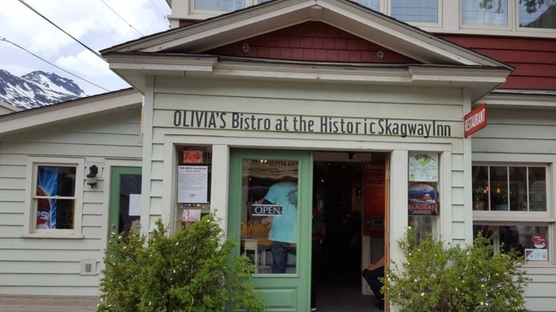 Olivia's Bistro at the Historic Skagway Inn entrance with snow-covered mountain the background
