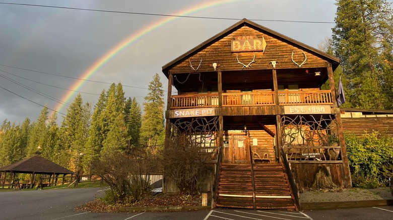 The log cabin Snake Pit cafe and bar with a rainbow overhead
