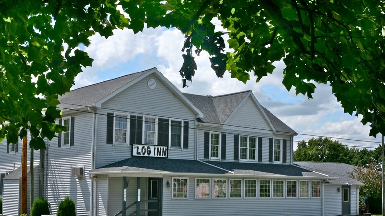 The Log Inn framed by green leaves