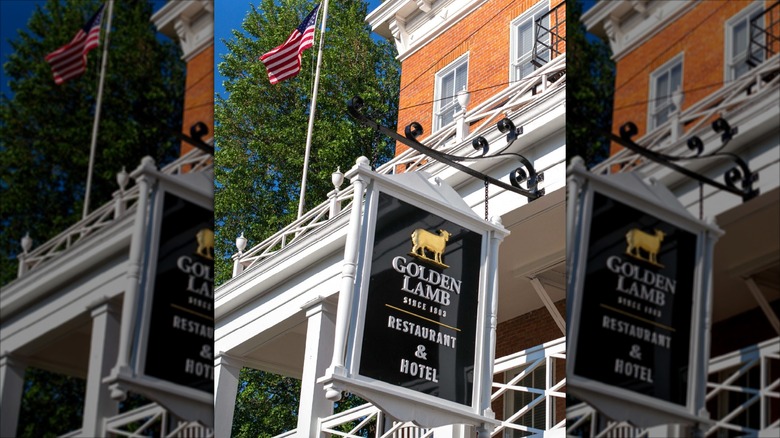 Outside view of the red brick Golden Lamb building with sign and flag