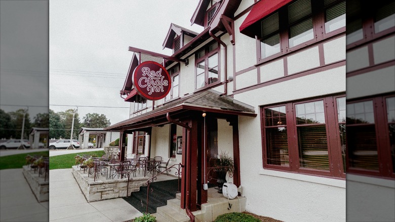 Outside view of Red Circle Inn with hanging sign and patio dining