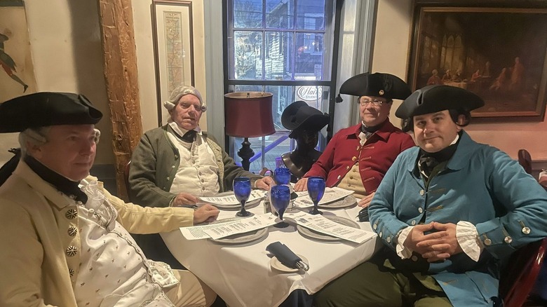 '76 House interior with men dressed in Revolutionary garb