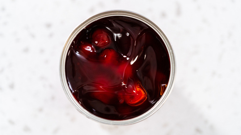 Aerial view of an opened can of cherry pie filling on white counter