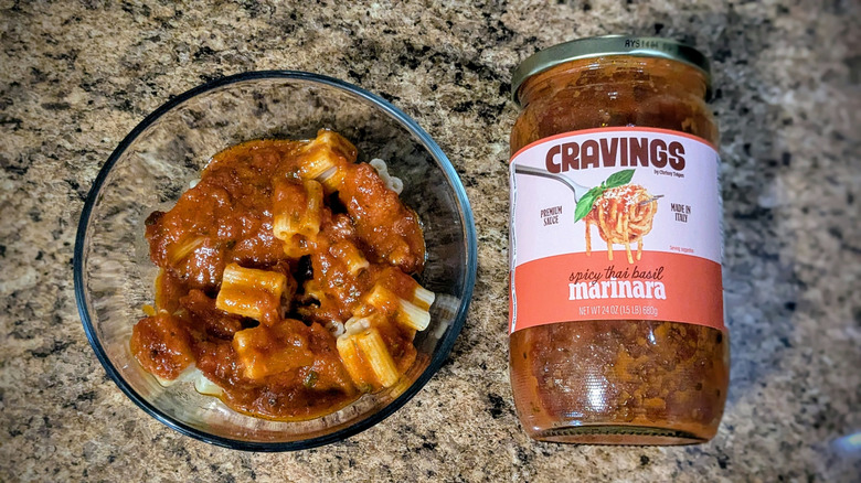 Cravings marinara sauce next to a bowl of pasta topped with the sauce