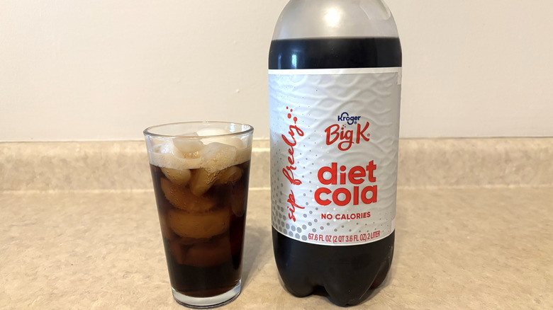 glass of Diet Big K next to two-liter bottle on counter