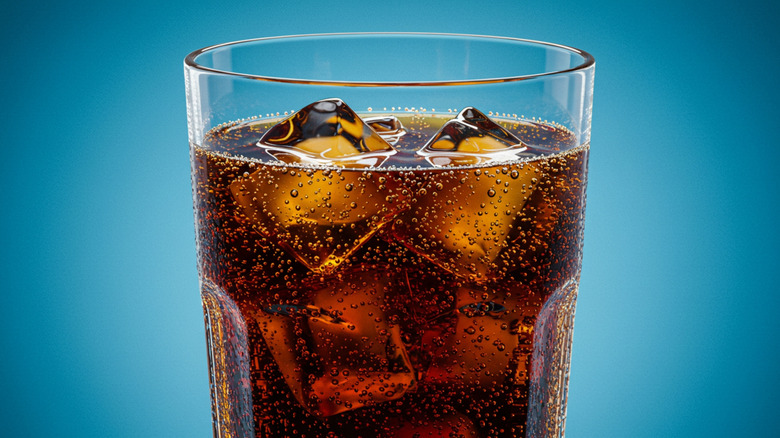 Close-up of cola in a glass with blue background