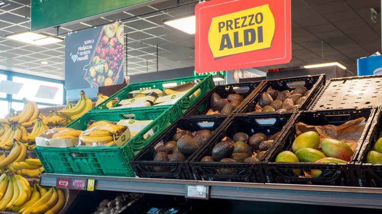 The Aldi produce aisle with containers of avocados, mangoes, and bananas