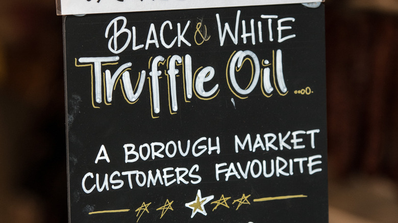 A black sign advertising Black and White Truffle Oil