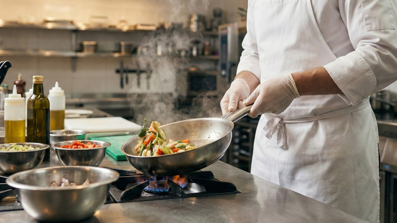 A chef sauteés vegetables