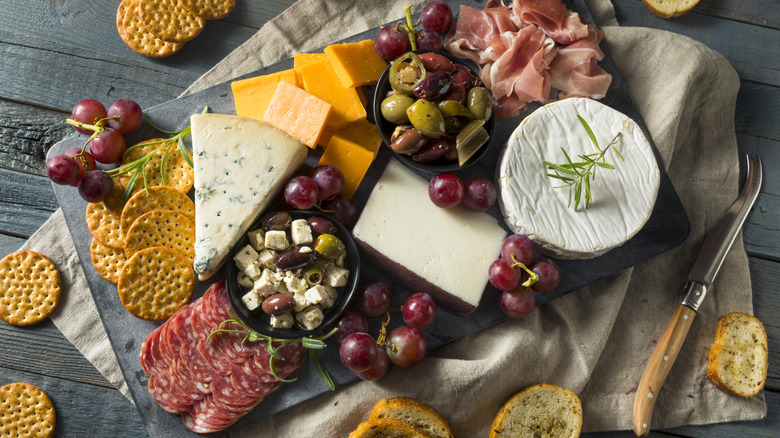 A charcuterie board of cheese, fruits, and crackers