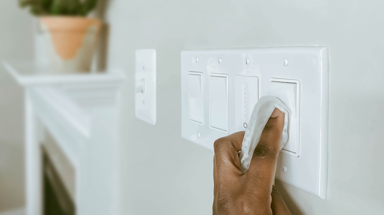 Hand cleaning light switches with cloth