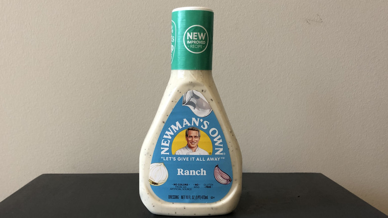 a bottle of Newman's Own ranch dressing on a black table in front of a white wall
