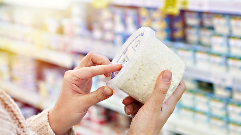 person buying cottage cheese at store