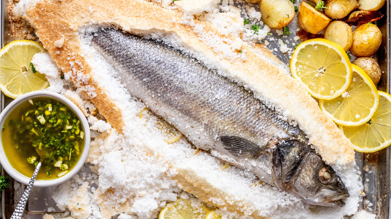 Whole fish covered in salt on tray
