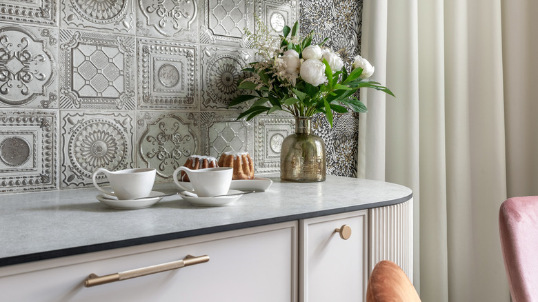 Patterned backsplash with counter and drapes
