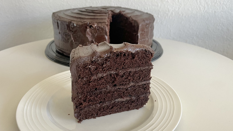 A slice of Costco Chocolate Fudge Cake in front of the cut cake