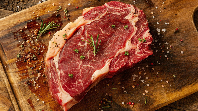 Raw steak on a wooden cutting board