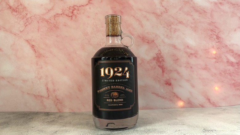 Bottles of 1924 Whiskey Barrel Aged Red Blend against pink marbled background