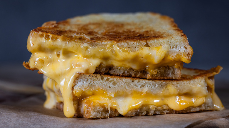 a grilled cheese sliced in half and oozing cheese