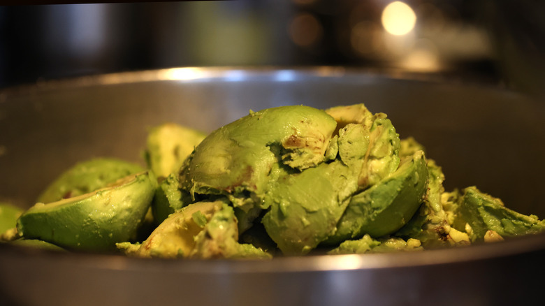 Avocados in a bowl prepped for guacamole