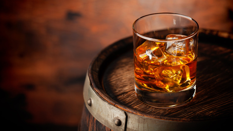 A bourbon on rocks atop barrel