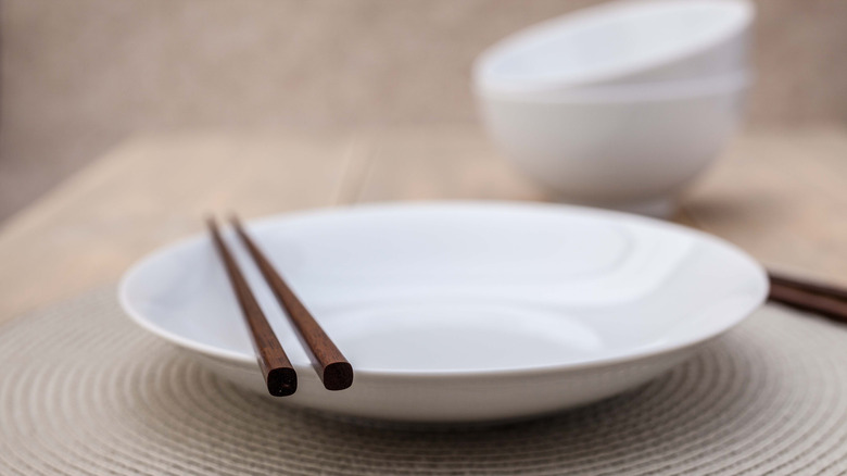 Chopsticks resting on empty plate