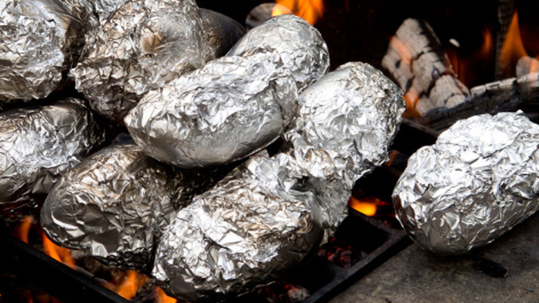 Baked potatoes in foil on a campfire