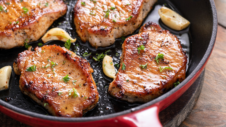 Overhead view of seared pork chops in a pan