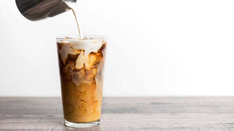 creamer pouring in iced coffee