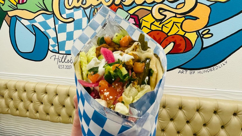 Twisted Gyro in front of painting at Oregon restaurant