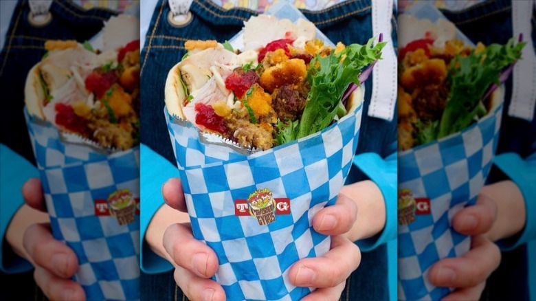 person holding a stuffed gyro from Oregon's Twisted Gyros