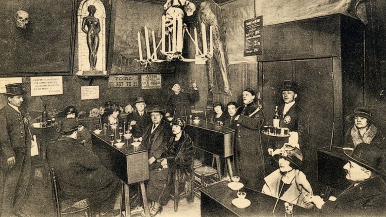 inside of Cabaret du Neant with people sitting at coffin tables