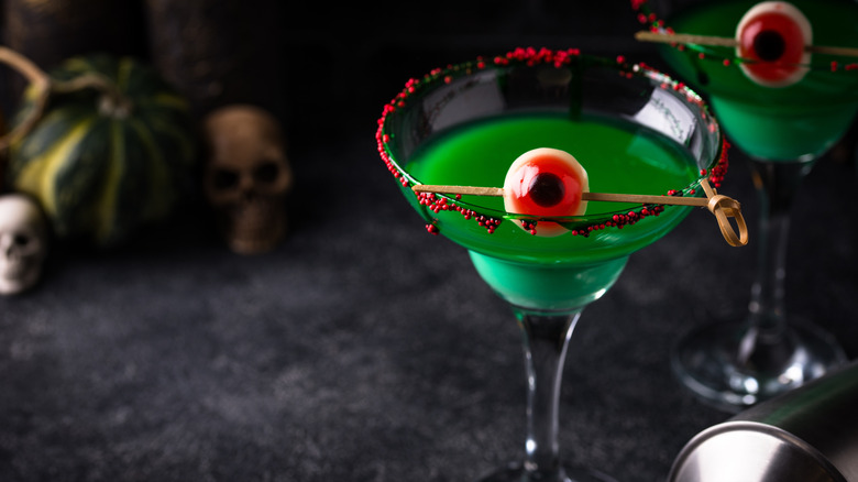 Green cocktails with eyeball garnish on skewer