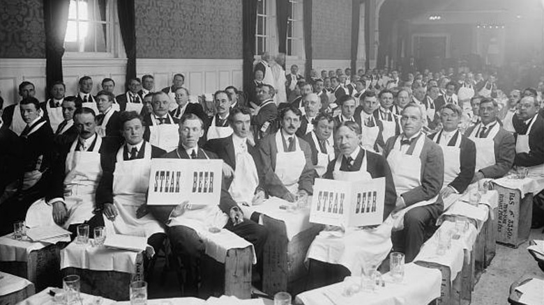 Men wearing aprons sitting on crates at beefsteak dungeon