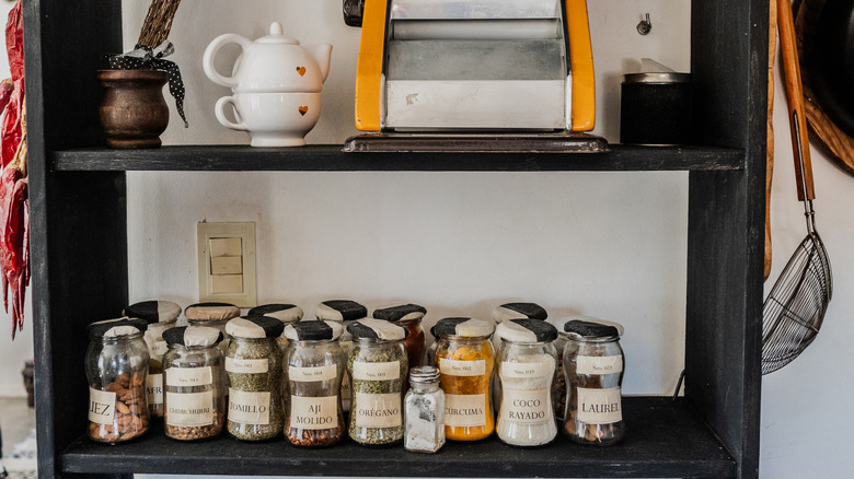 Labeled spice jars on kitchen shelf