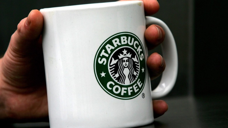Hand holding a Starbucks branded mug