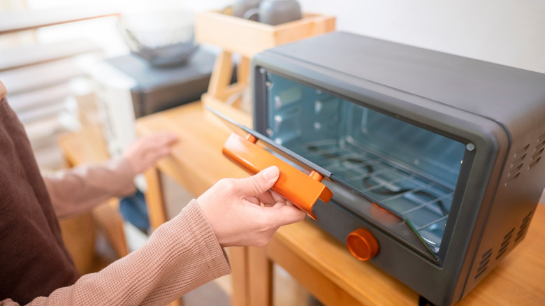 Person opening a toaster oven