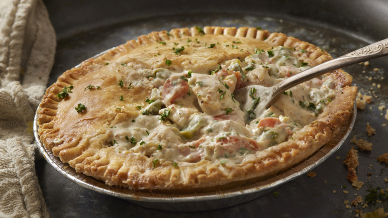 chicken pot pie in an aluminum tin with a spoon sticking out