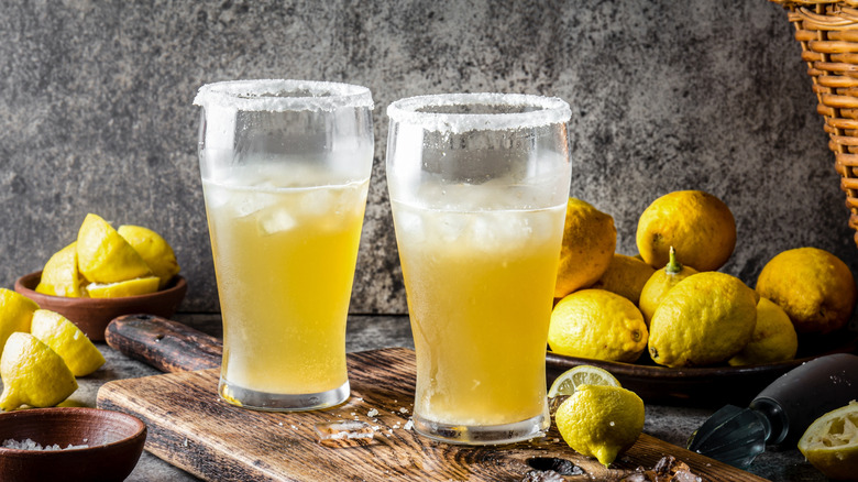 two light beers with salty rims surrounded by lemons