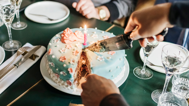 A birthday cake being sliced
