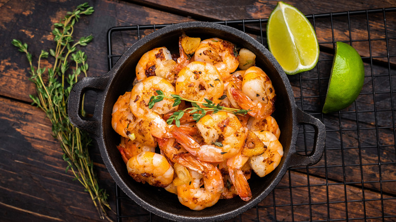 Crock of cooked shrimp with lime wedges