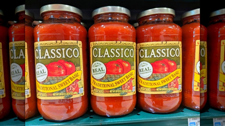 Three large Classico jars of tomato sauce, lined up on a store shelf.