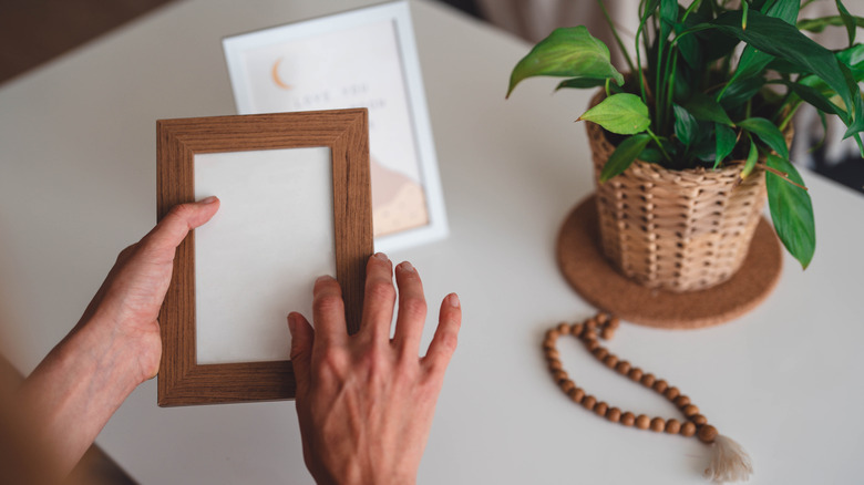 Hands holding frame over kitchen counter