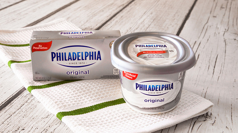 Philadelphia cream cheese containers on white and green kitchen towel